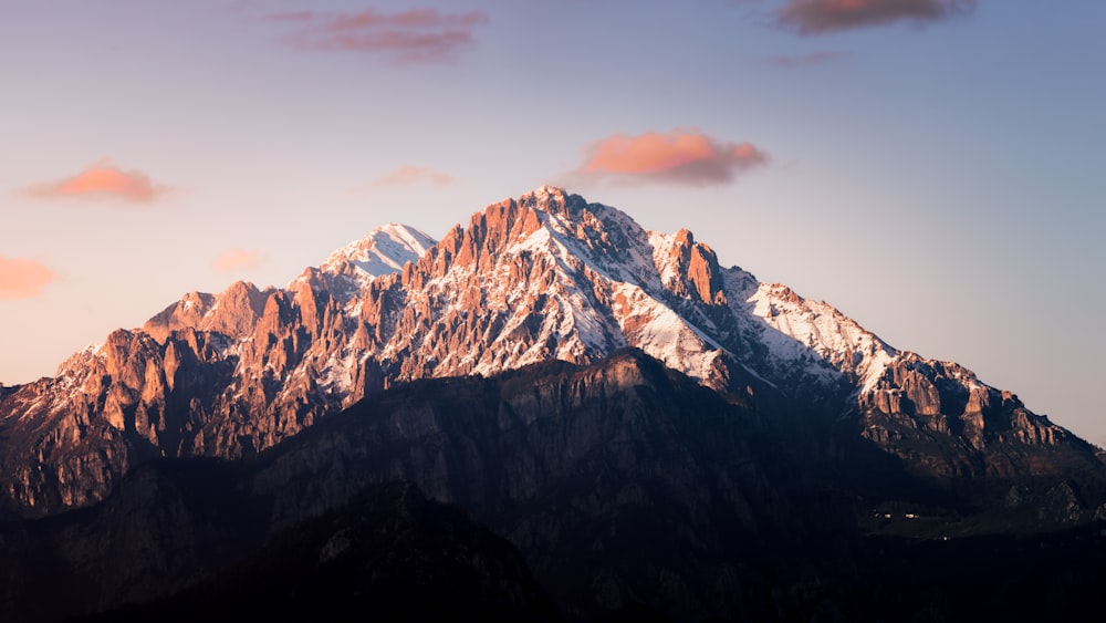 a snow covered mountain with a pink sky in the background