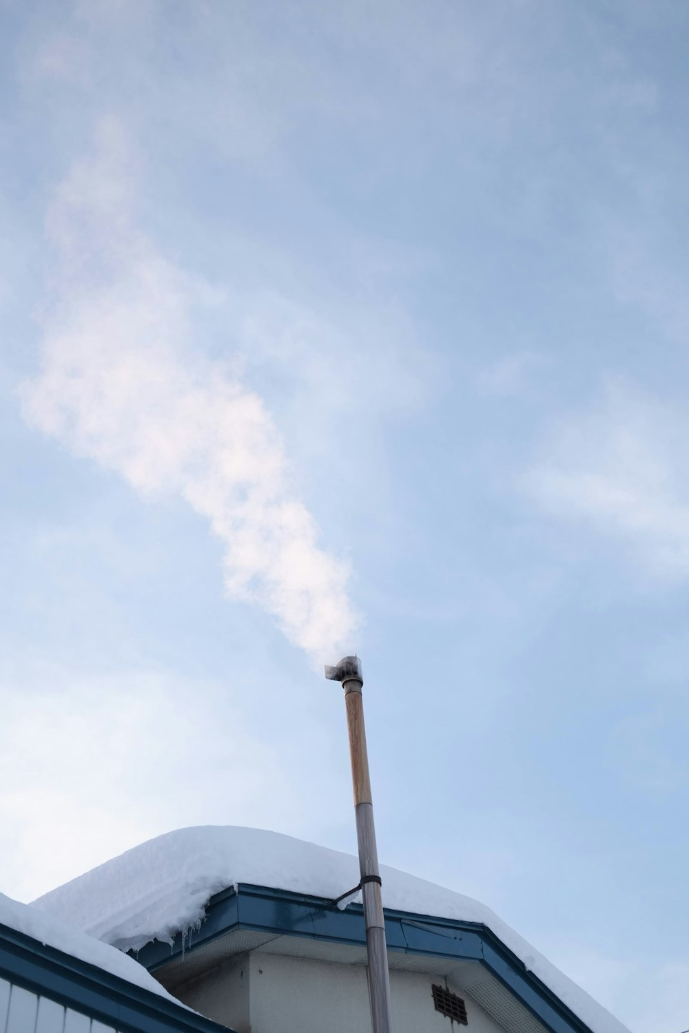 smoke coming out of a chimney on top of a building