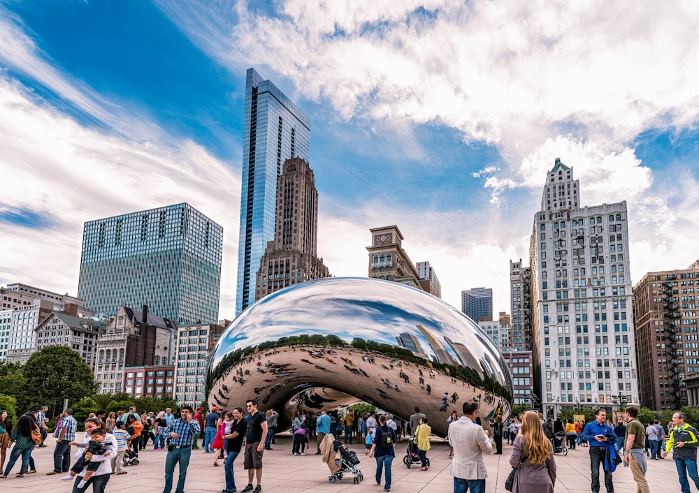 a group of people standing around a large shiny object