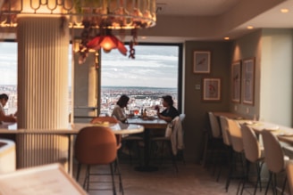 A cozy café terrace with people enjoying meals and city views.