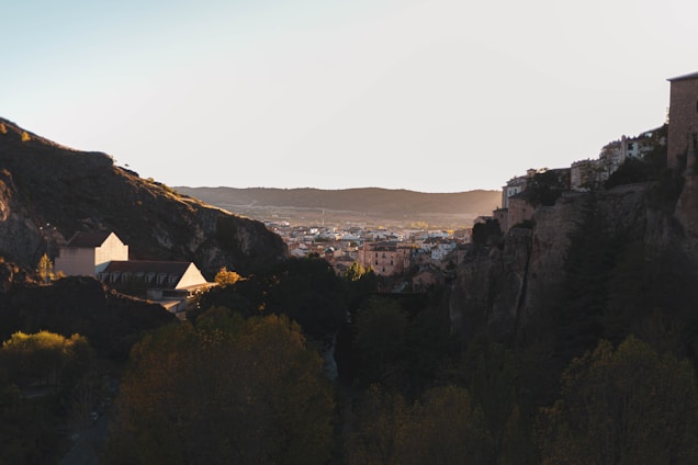 A serene landscape blending ancient ruins with modern life under a vibrant sunset.