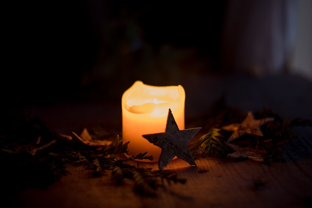 a lit candle with a star on top of it