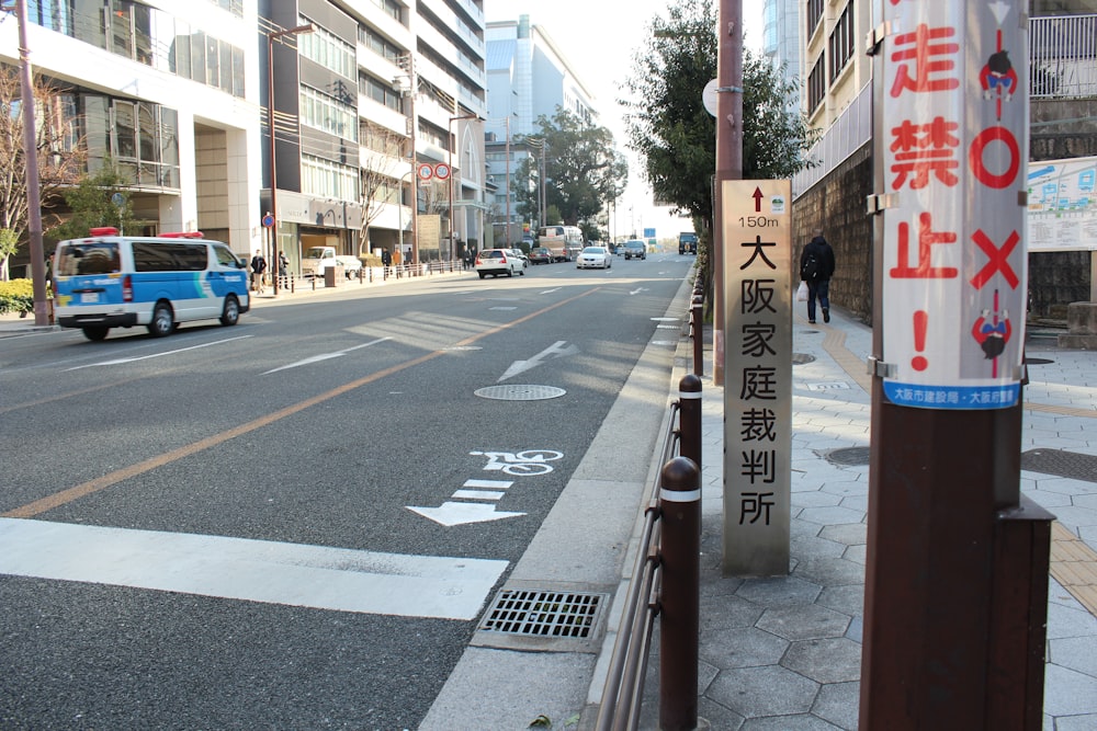 a city street with a blue truck driving down it