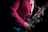 a man in a red suit holding a saxophone
