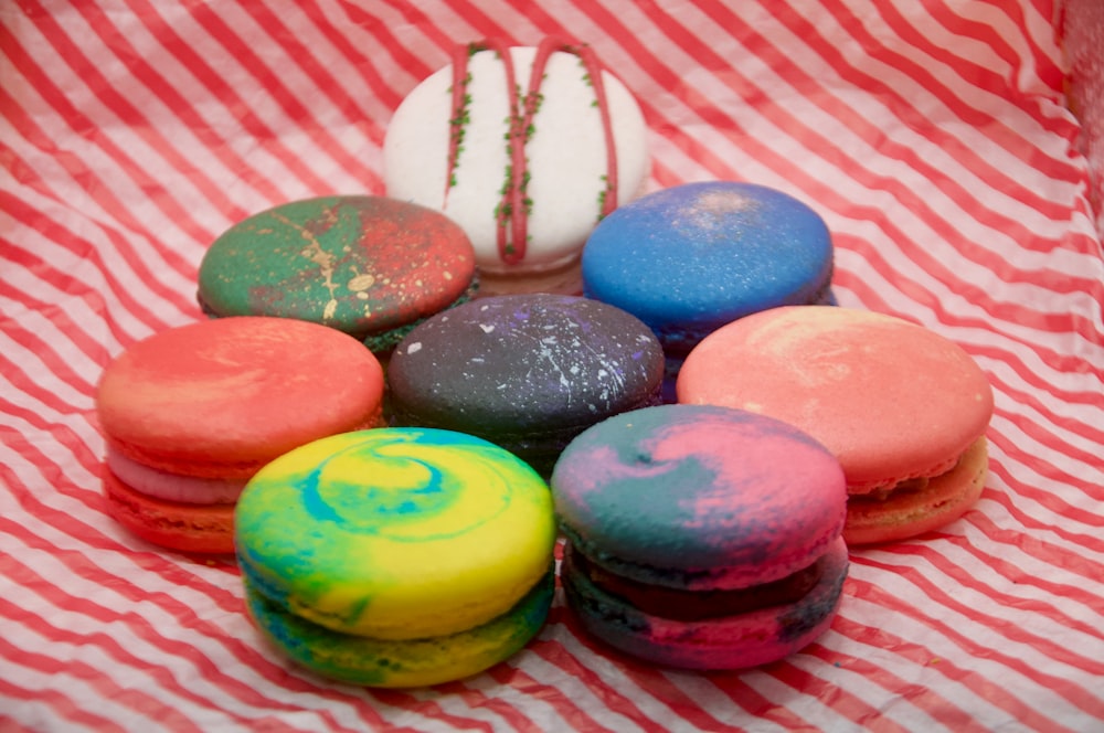 a pile of colorful macaroons sitting on top of a red and white striped