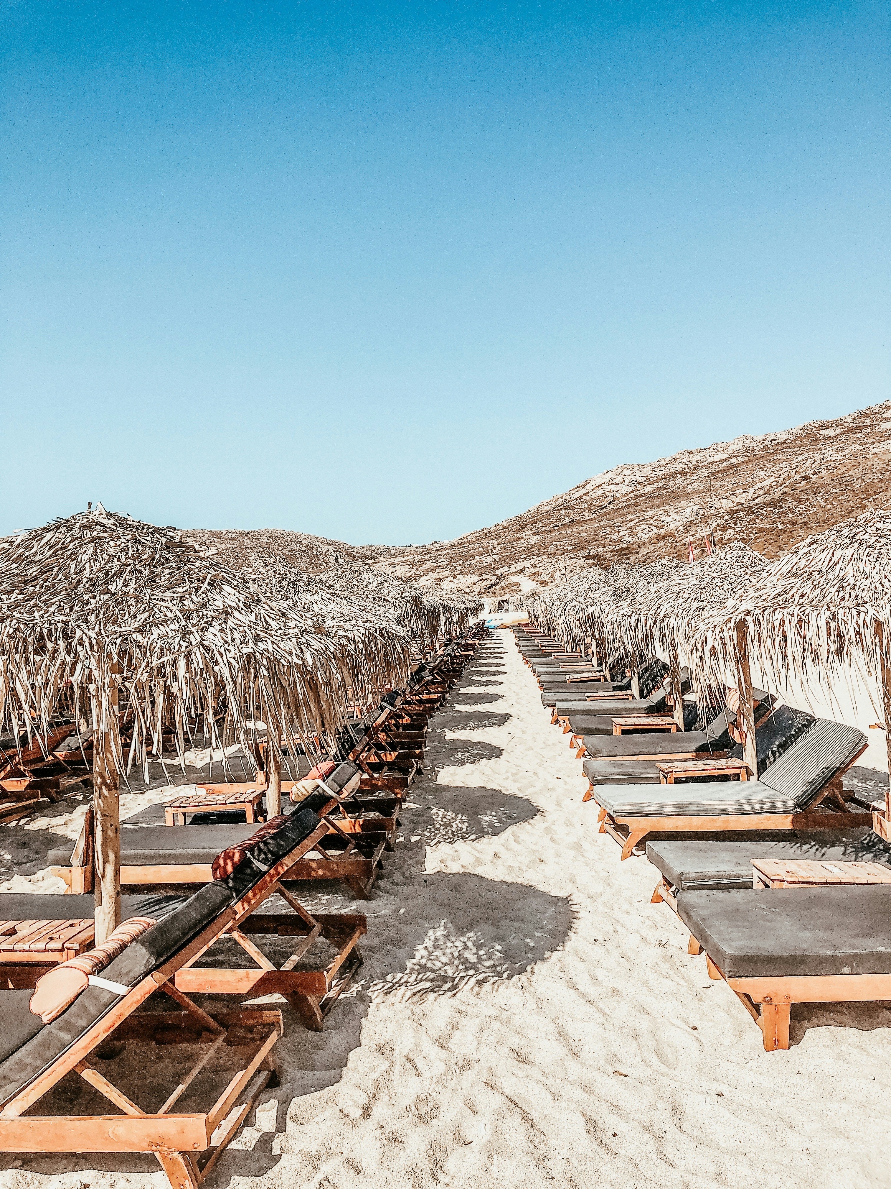Una fila de tumbonas sentadas encima de una playa de arena