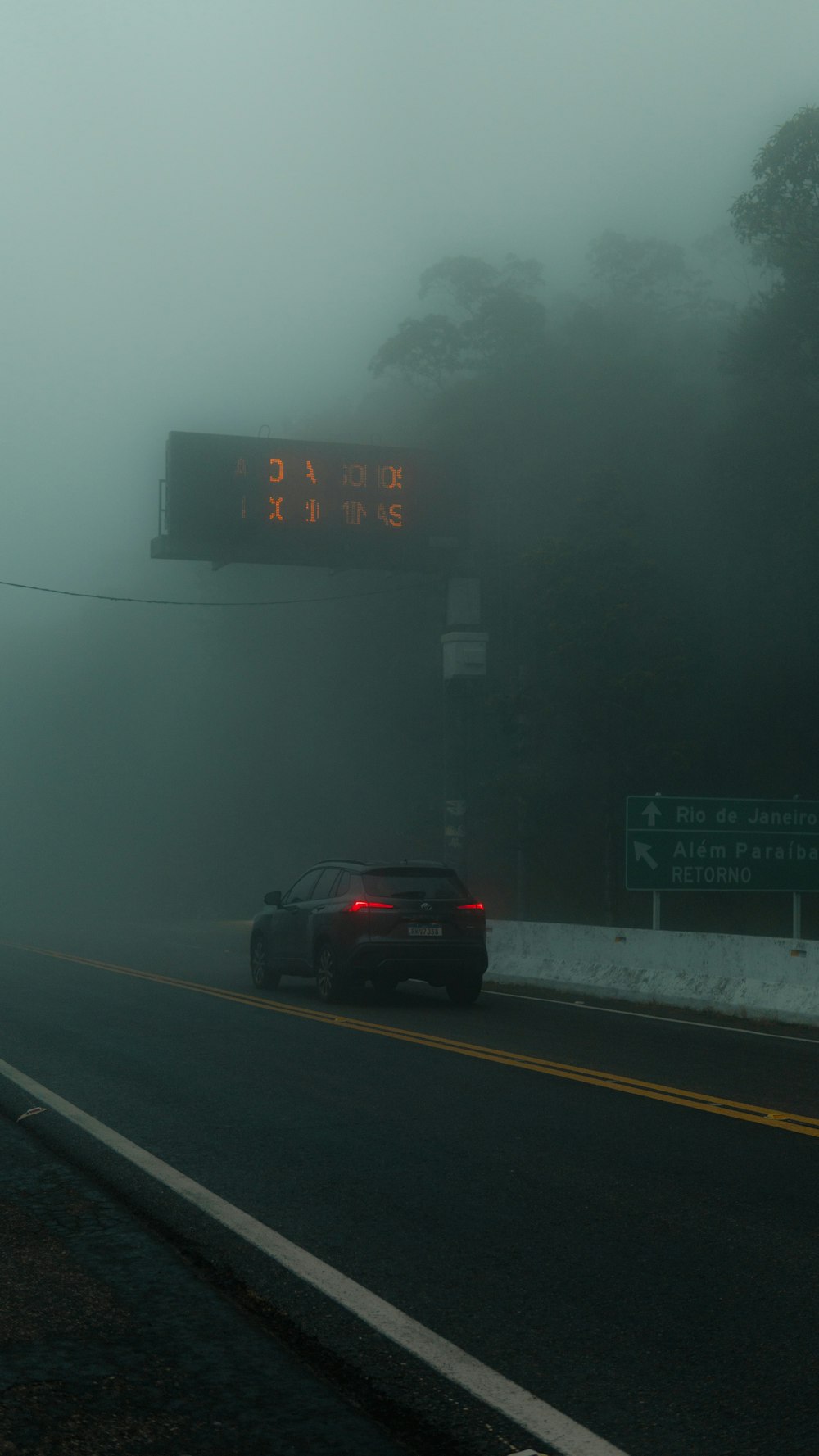 a car driving down a foggy road with a speed limit sign