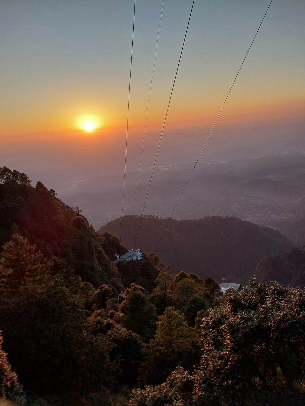 the sun is setting over a mountain range