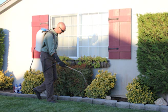 a man with a vacuum in front of a house