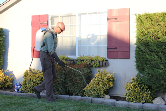 a man with a vacuum in front of a house