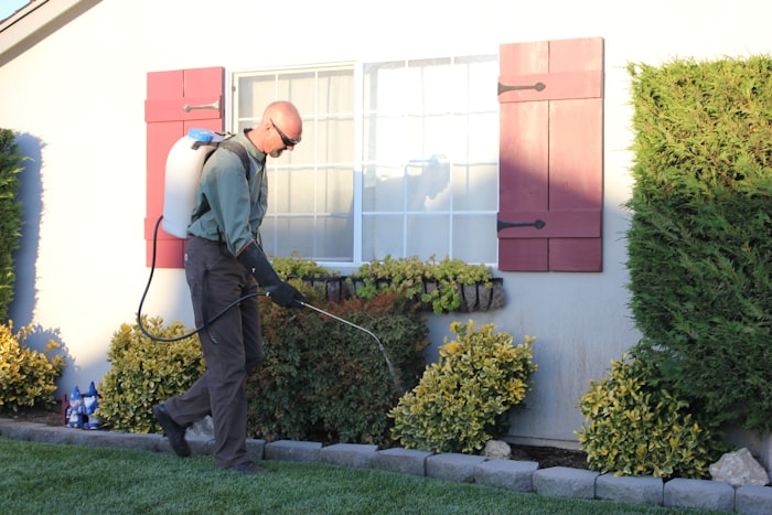 Technician applying liquid termite treatment along the foundation perimeter