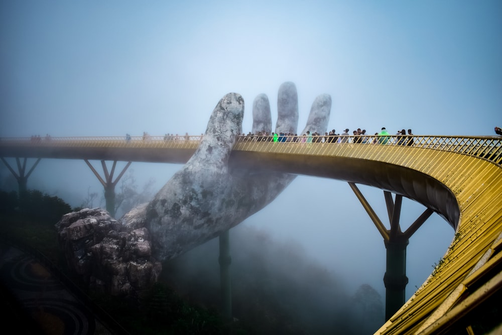 uma ponte que tem uma mão gigante sobre ela