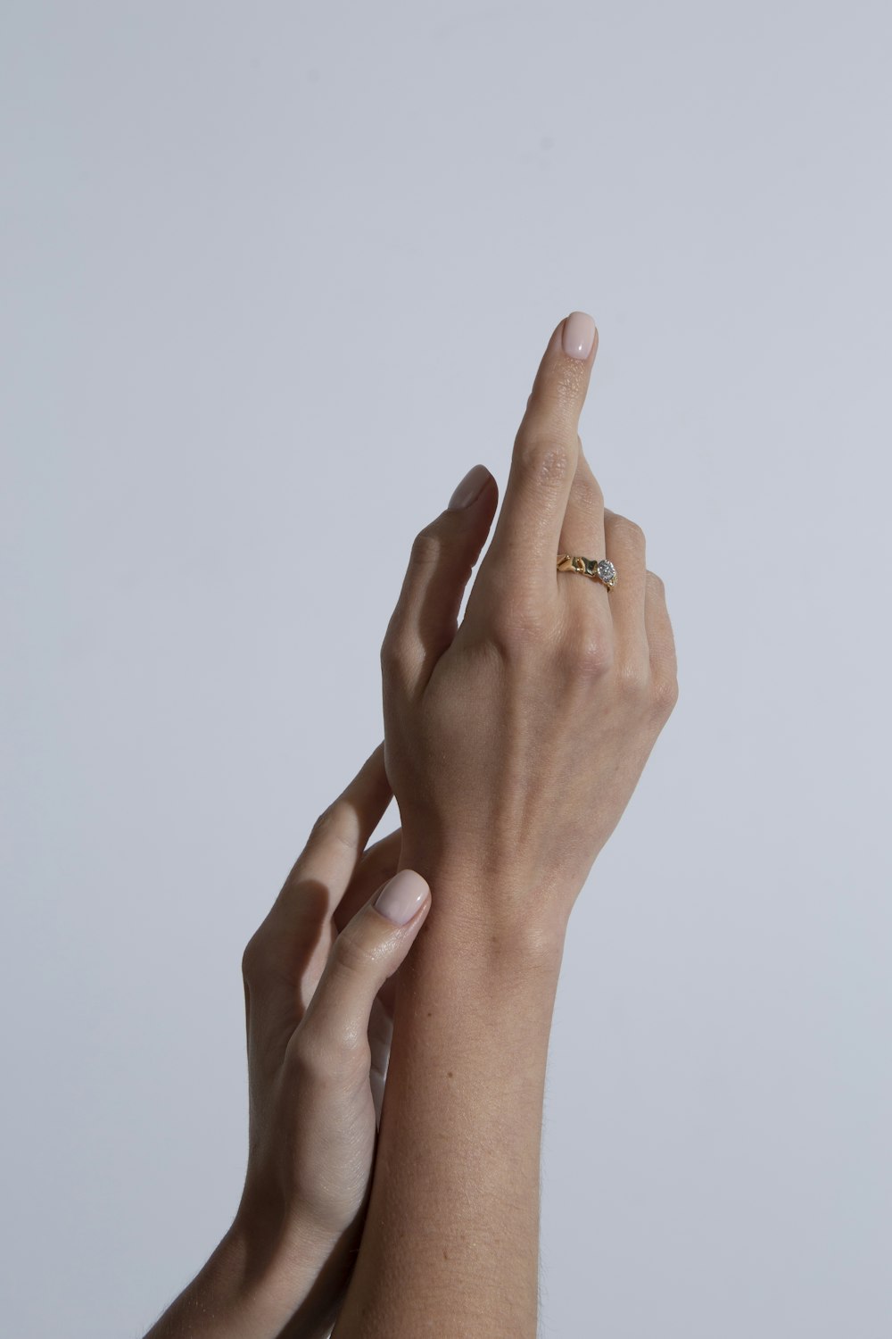 two hands reaching up towards each other with a ring on their finger