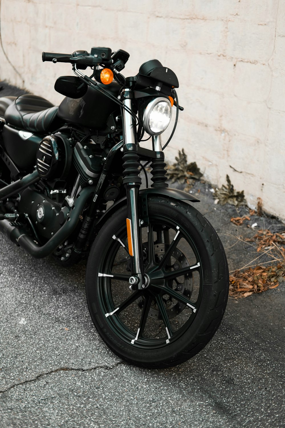 a black motorcycle parked next to a white wall