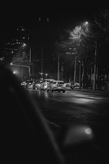 Urban scene with a variety of cars lined up, highlighted by sharp contrasts and dynamic lighting