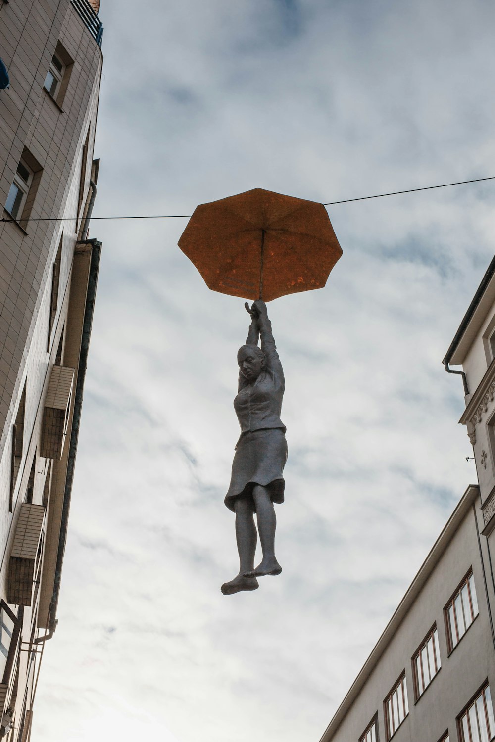 a statue of a man holding an umbrella