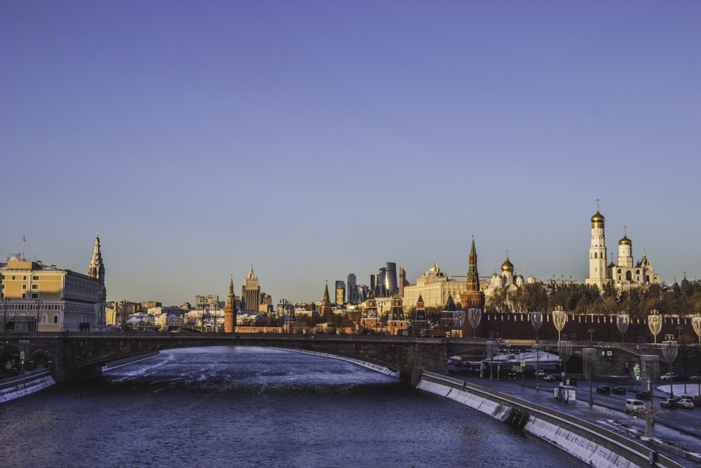 a bridge over a river with a city in the background