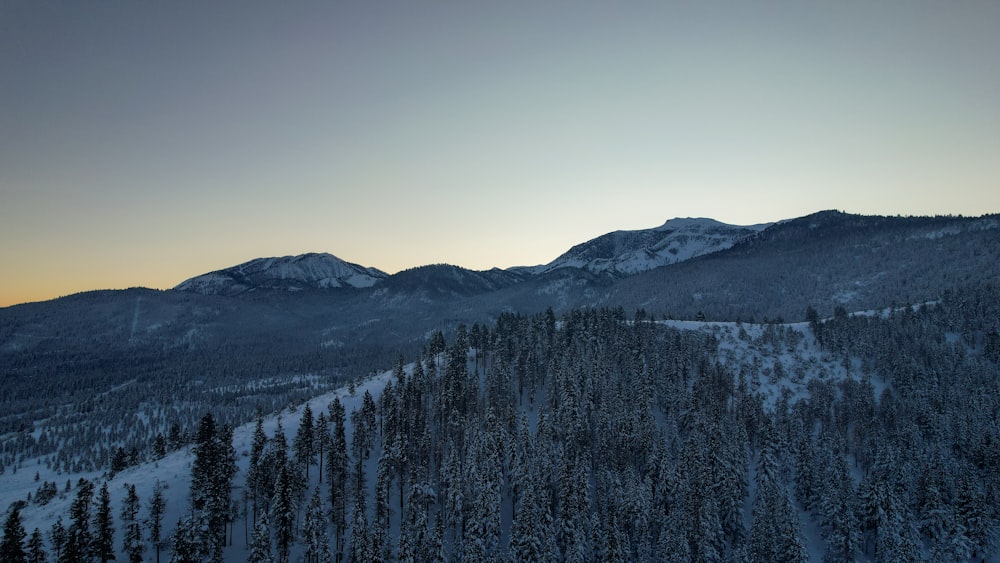 a view of a snowy mountain range at sunset