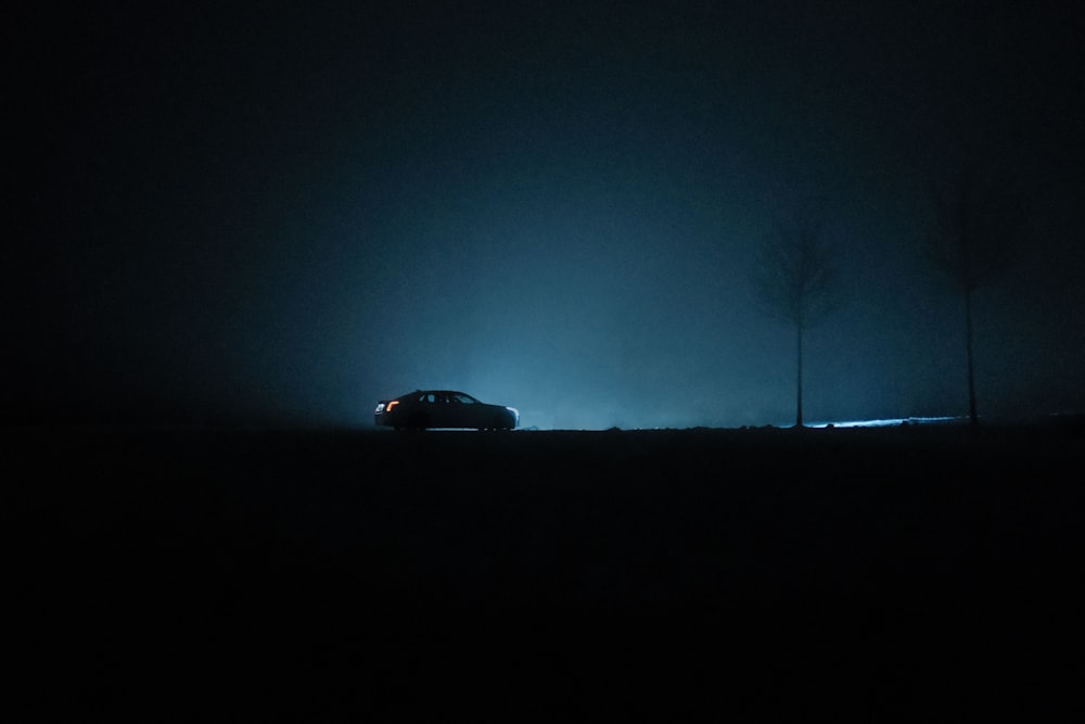 a car driving in the dark on a foggy night