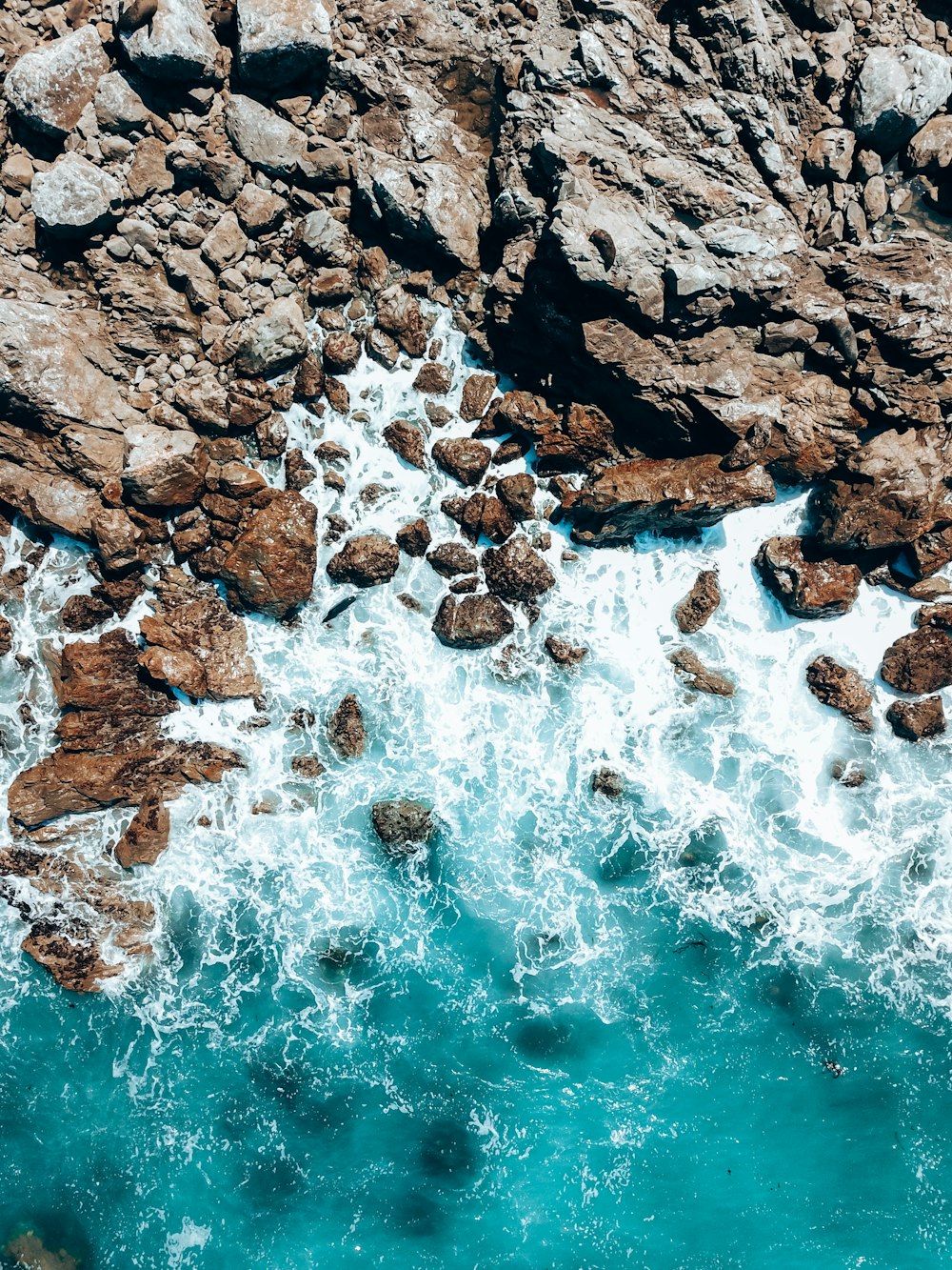 a bird's eye view of the ocean and rocks