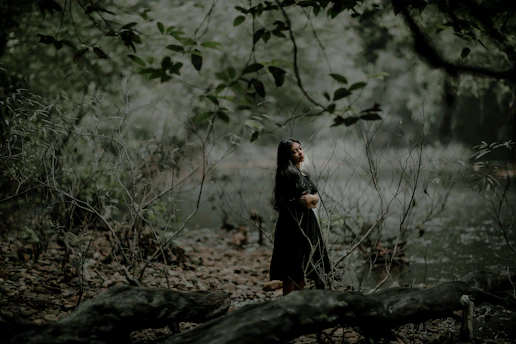A serene woman sitting peacefully in nature, eyes closed, embracing healing and calm.