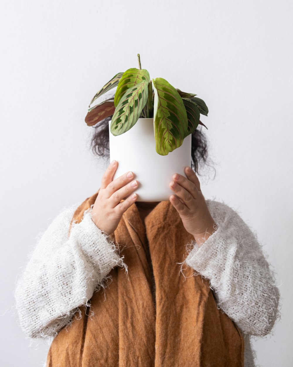 a woman holding a plant in front of her face