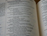 A close-up view of an open book displaying Biblical text. The pages feature chapters and verses with headings such as 'Woes and judgments' and text in a traditional font. The content includes structured, numbered lines.