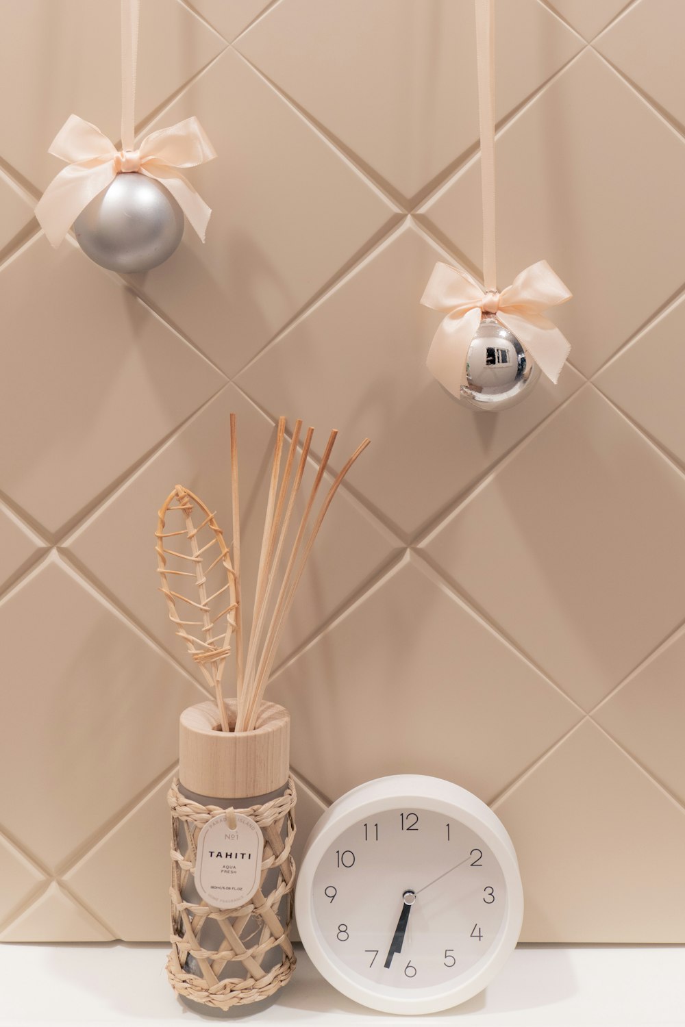 a clock and some reeds in a vase