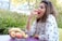 A happy woman enjoying a healthy fruit snack outdoors.