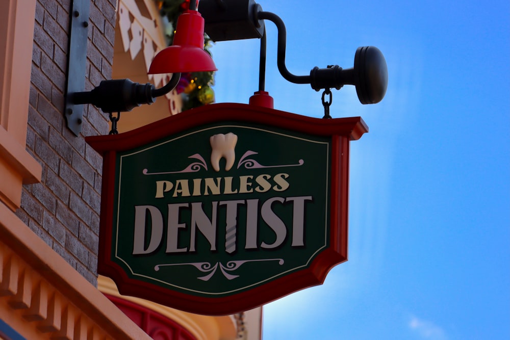 ein Schild mit der Aufschrift "Schmerzloser Zahnarzt" an der Seite eines Gebäudes