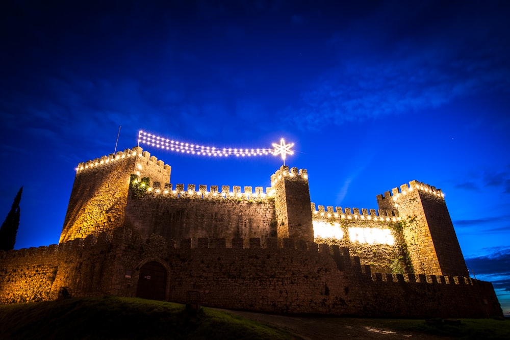 a castle lit up at night with lights on it