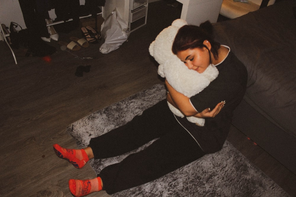 a woman sitting on a couch holding a pillow