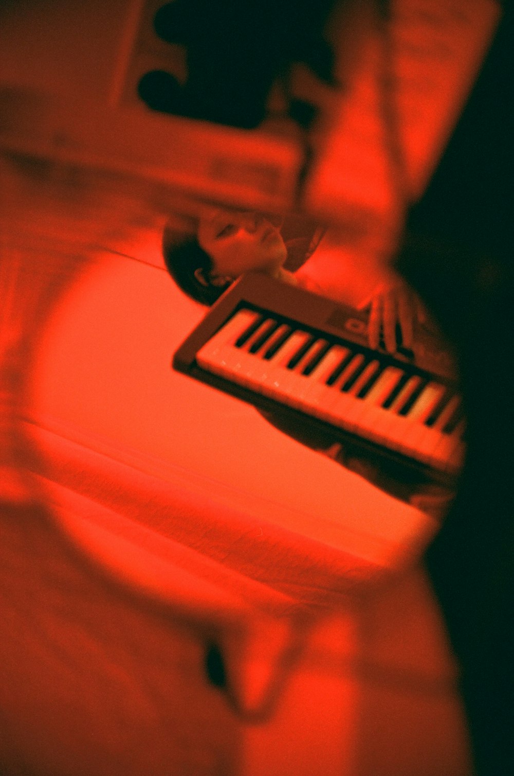 a person playing a piano with a red light
