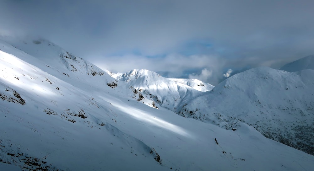 Une montagne couverte de neige sous un ciel nuageux