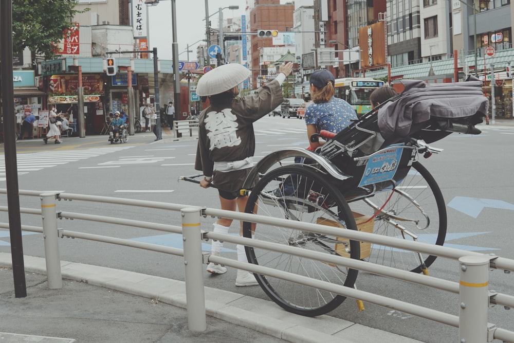 a person standing next to a bike on a city street