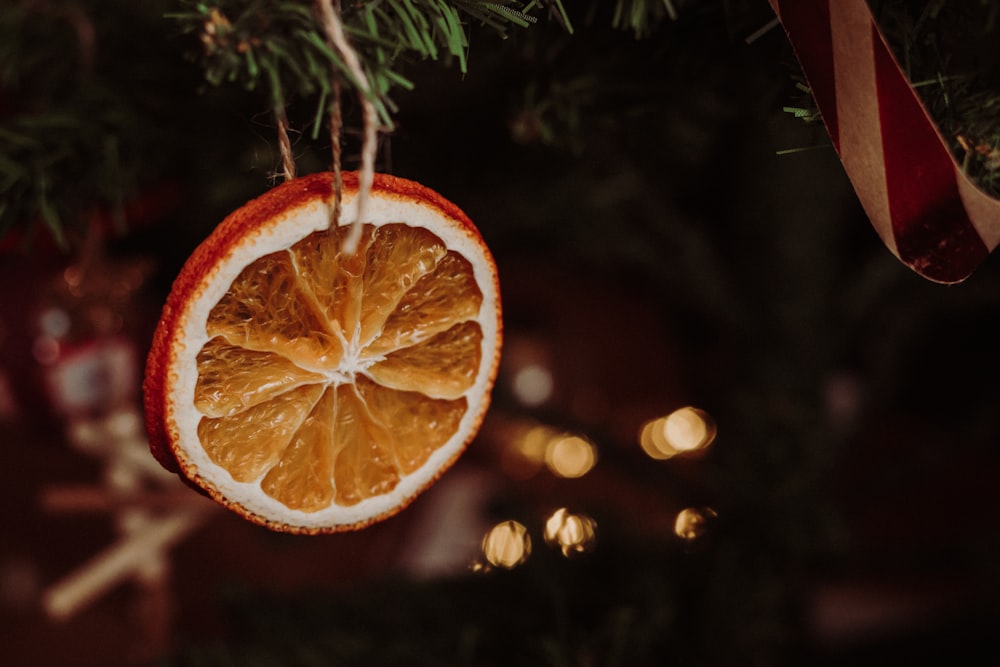 an orange cut in half hanging from a christmas tree