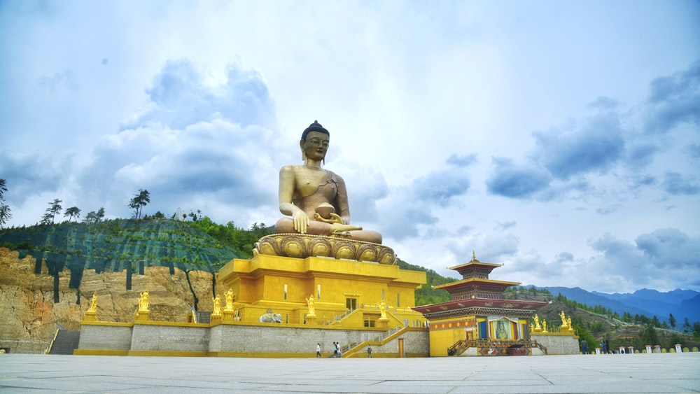 a large buddha statue sitting in front of a mountain