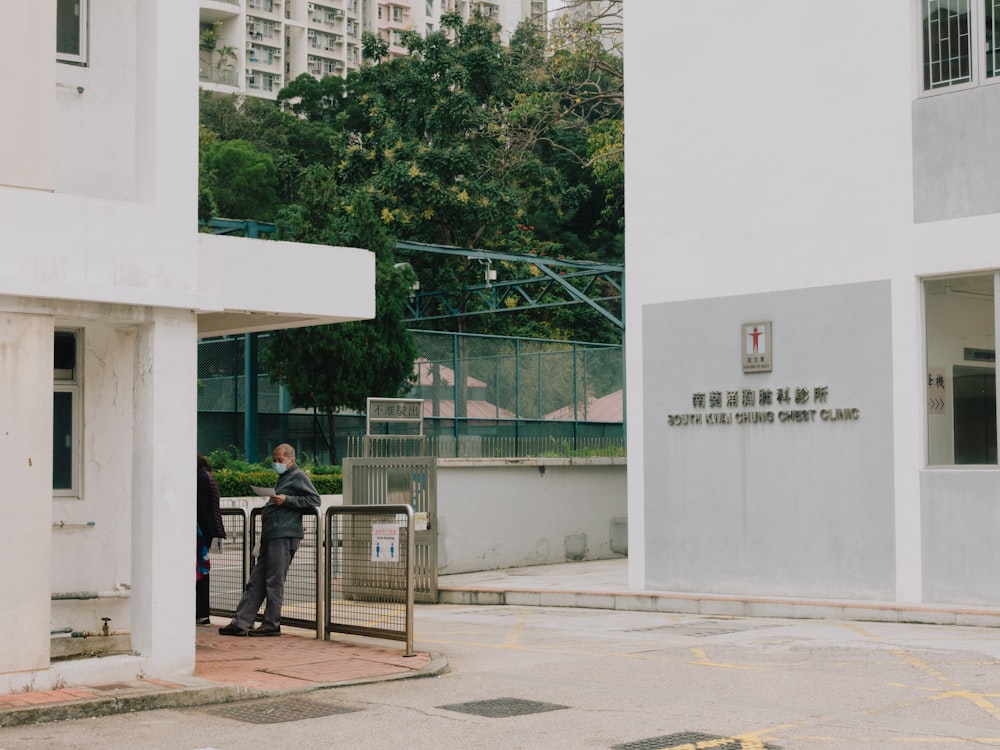 a man standing at a gate in front of a building