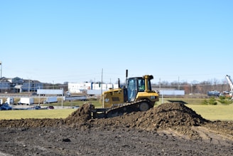 a bulldozer digging through a pile of dirt