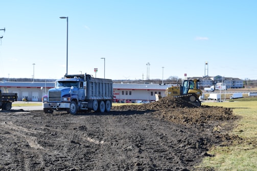 a dump truck driving down a dirt road