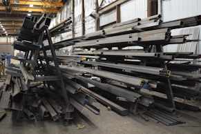 a large pile of steel beams in a warehouse