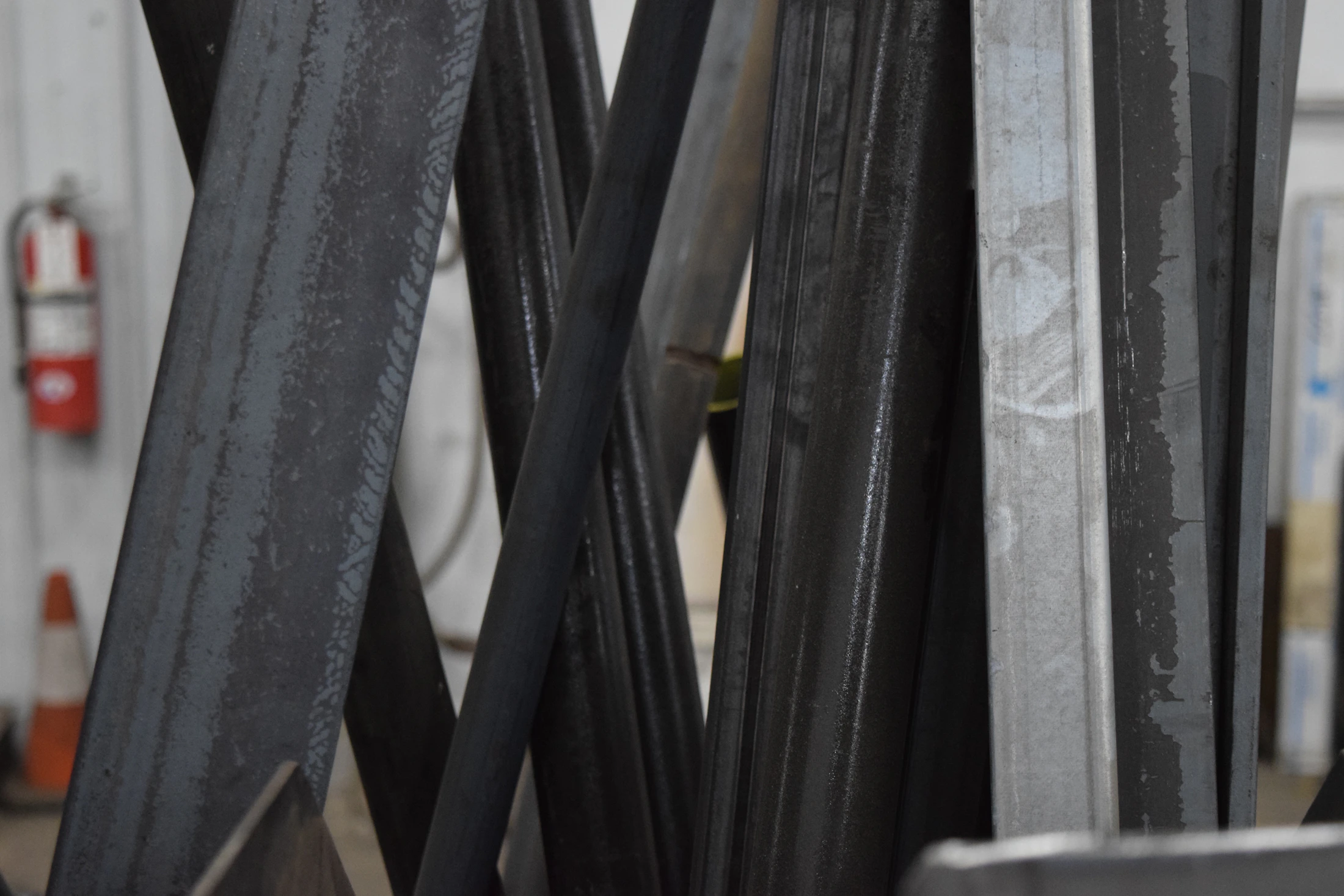 Stack of dark flat steel bars showing rectangular edges