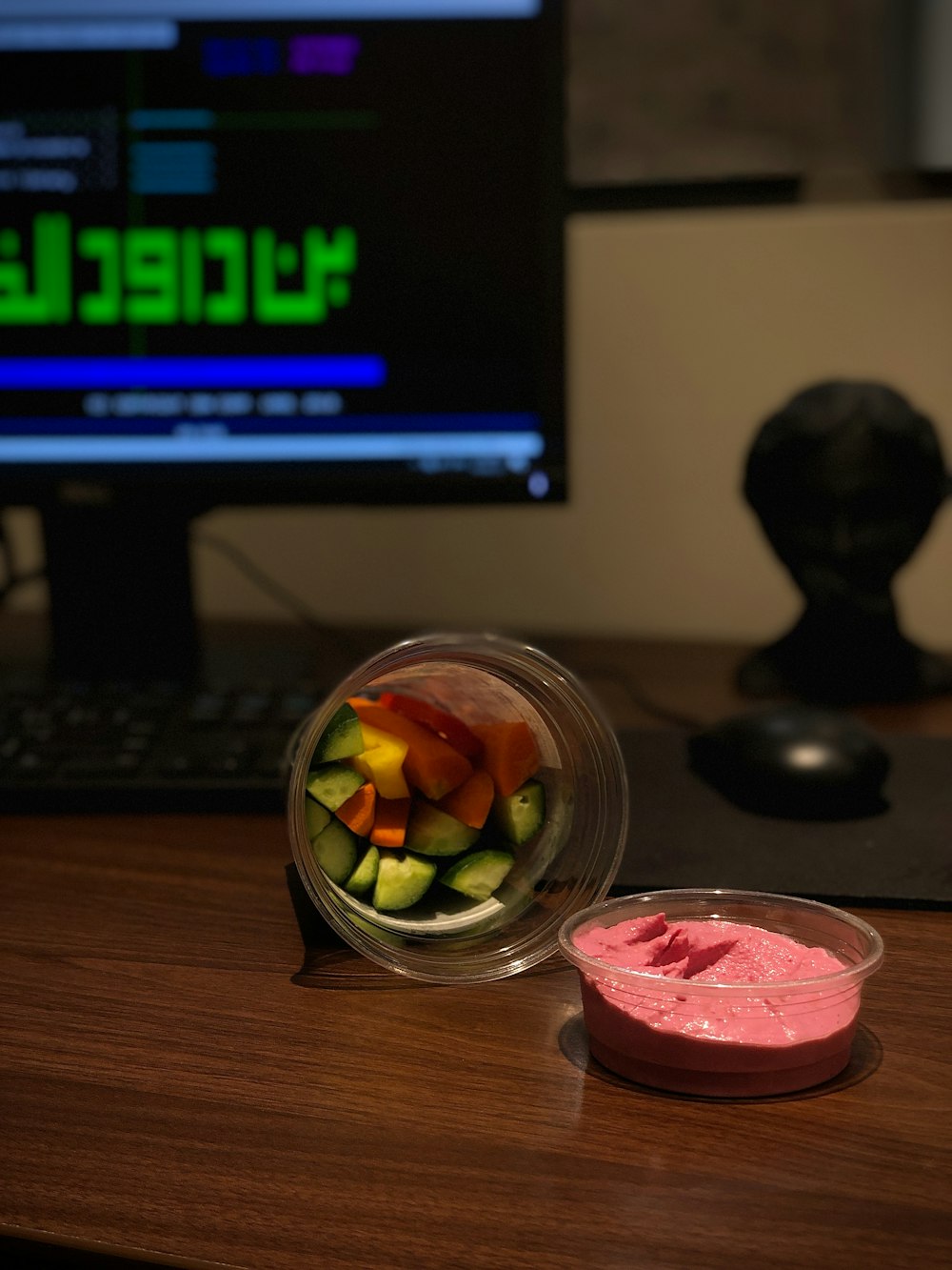 a computer desk with a computer monitor and a bowl of fruit