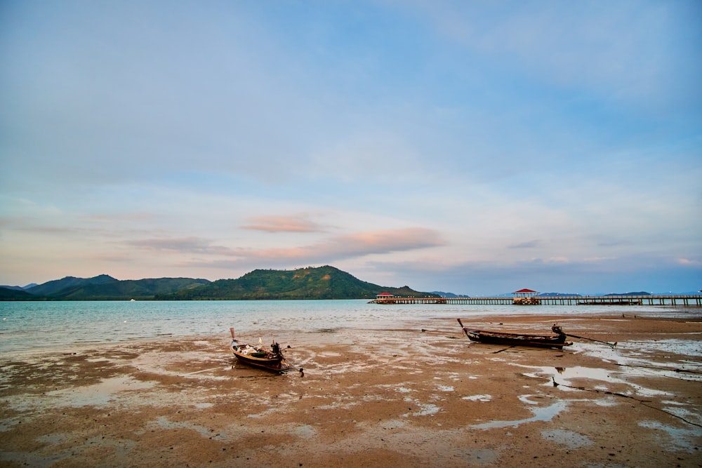 a couple of boats sitting on top of a beach