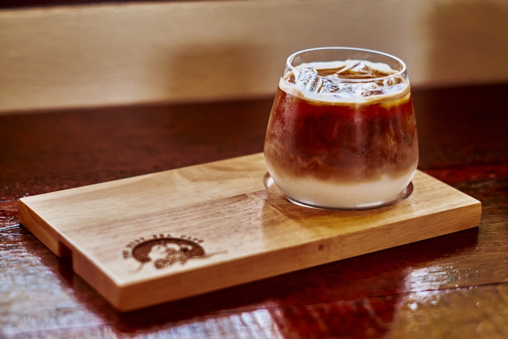 a wooden tray with a drink on top of it
