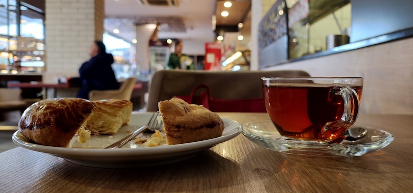 A cozy table at Tattershall Castle Cafe with a cream tea set and a view of the castle grounds.
