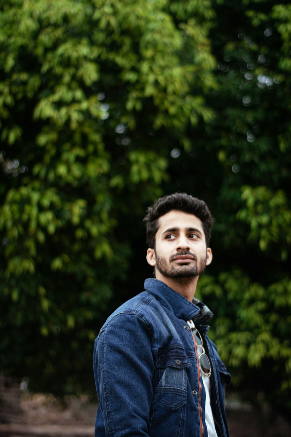 a man standing in front of some trees