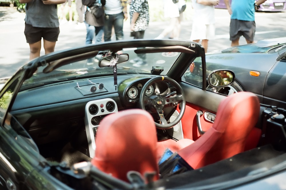 a car with a steering wheel and a red seat