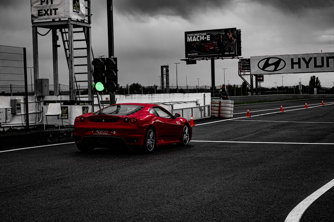 a red sports car driving down a race track,