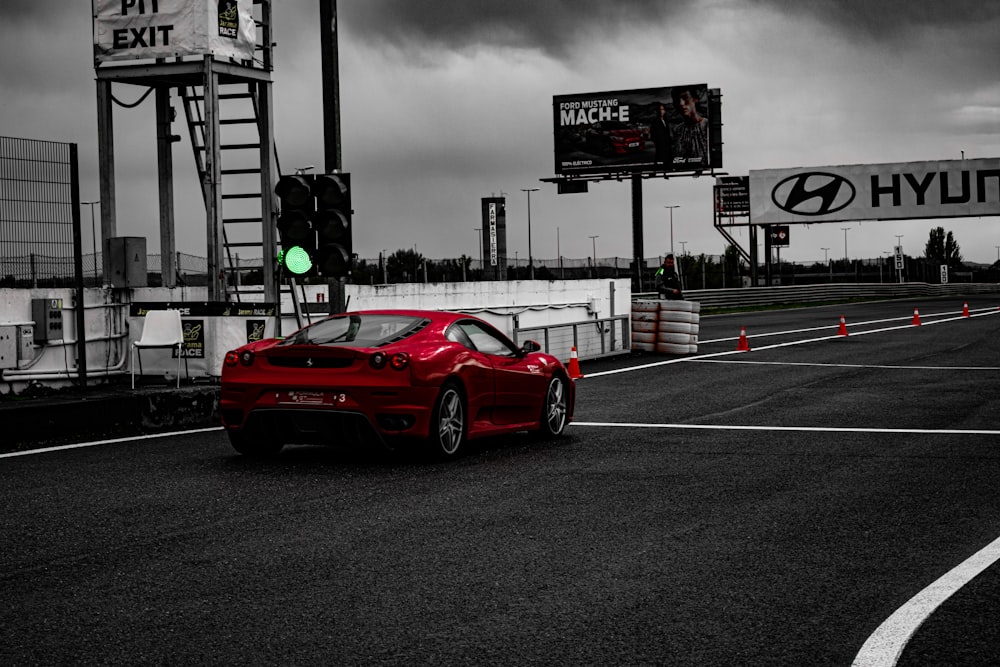 Une voiture de sport rouge roulant sur une piste de course